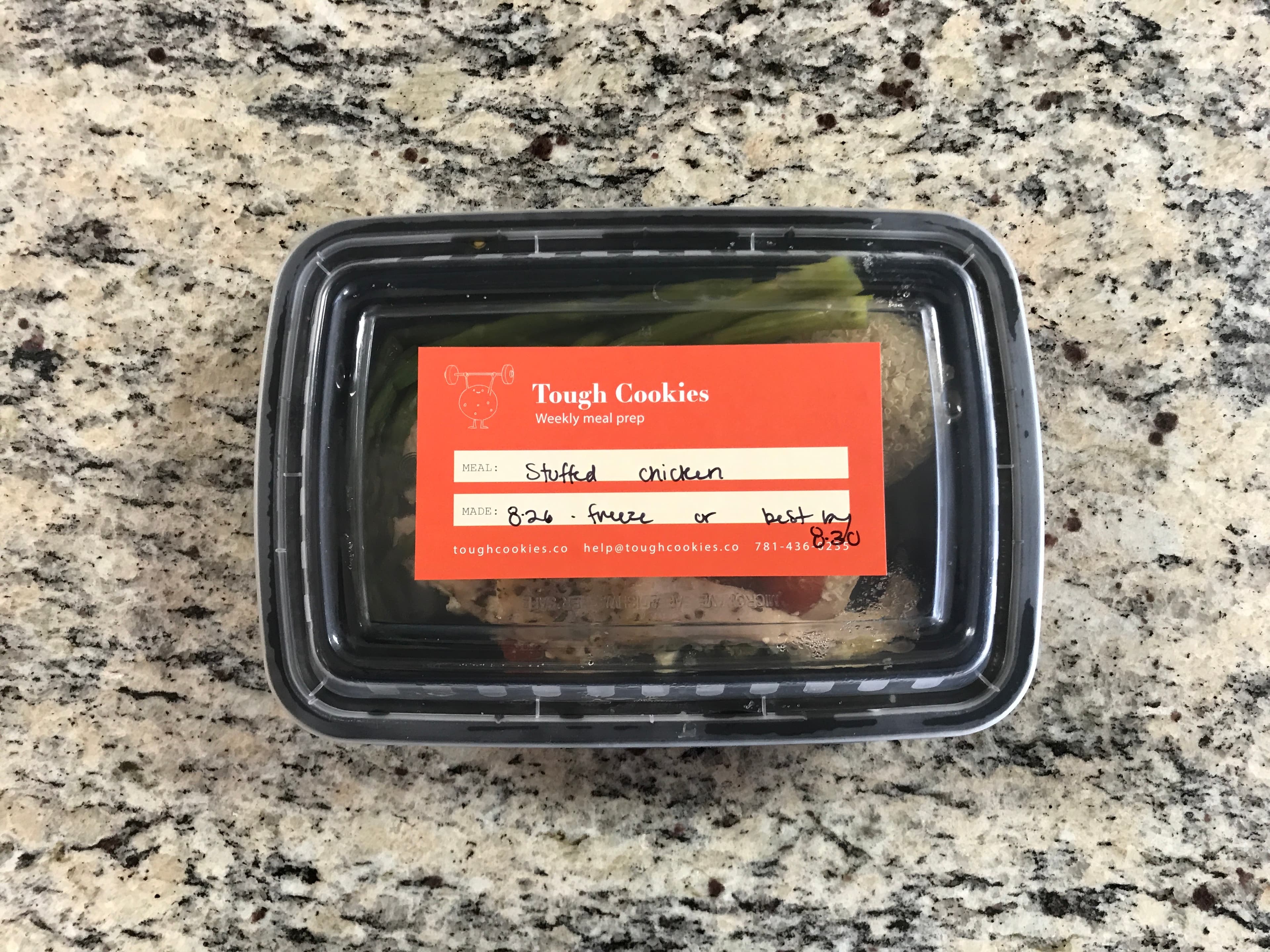 An early Tough Cookies meal container with an orange label filled out by hand